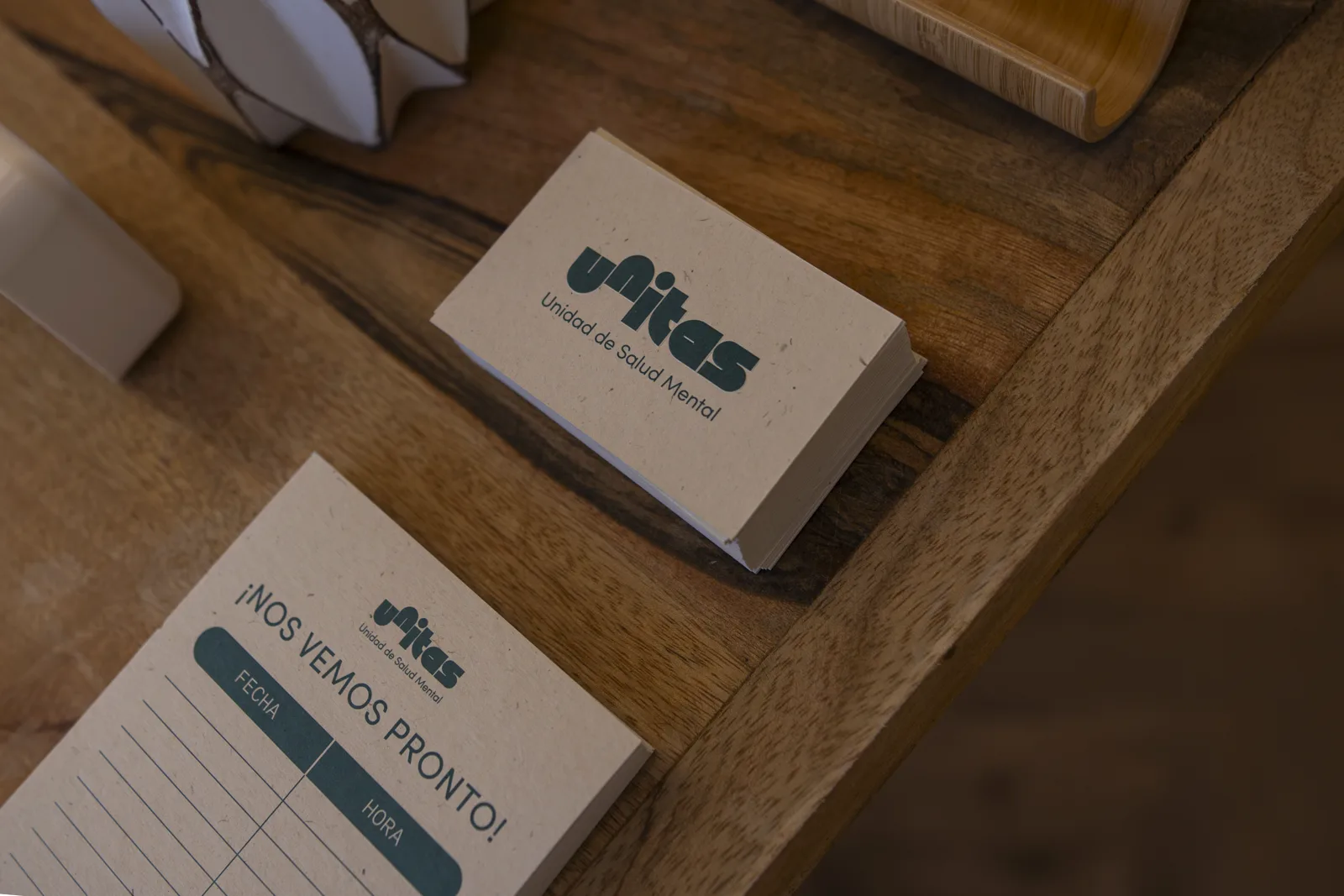 Tarjetas de visita de Clínica Unitas junto a una nota que dice «¡Nos vemos pronto!»