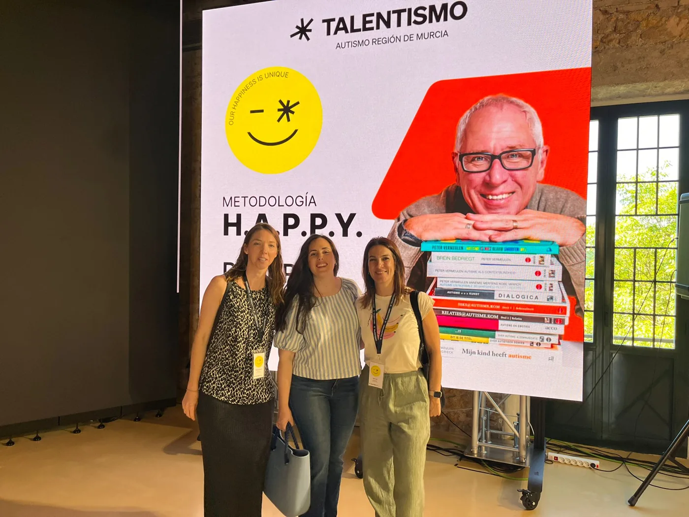 Tres integrantes del equipo de Clínica Unitas en una formación sobre autismo de TALENTISMO, ante una gran pantalla que anuncia la metodología H.A.P.P.Y.