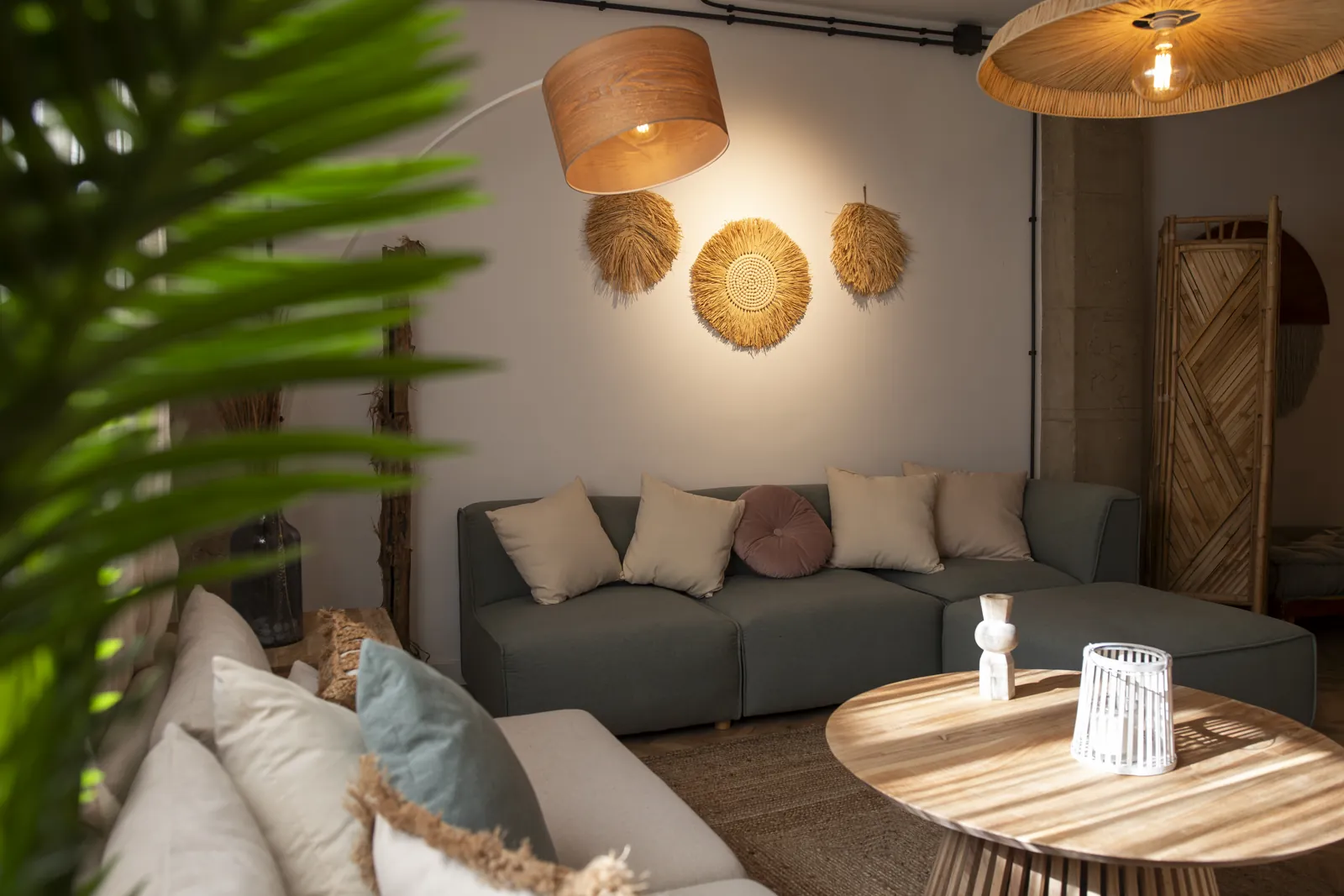 Sala común de la clínica con sofás, cojines, lámparas de madera y una mesa redonda